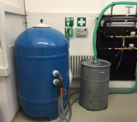 Aktivkohlefilter und Schlauchleitungen zur Grundwassersanierung im Keller eines Gebäudes